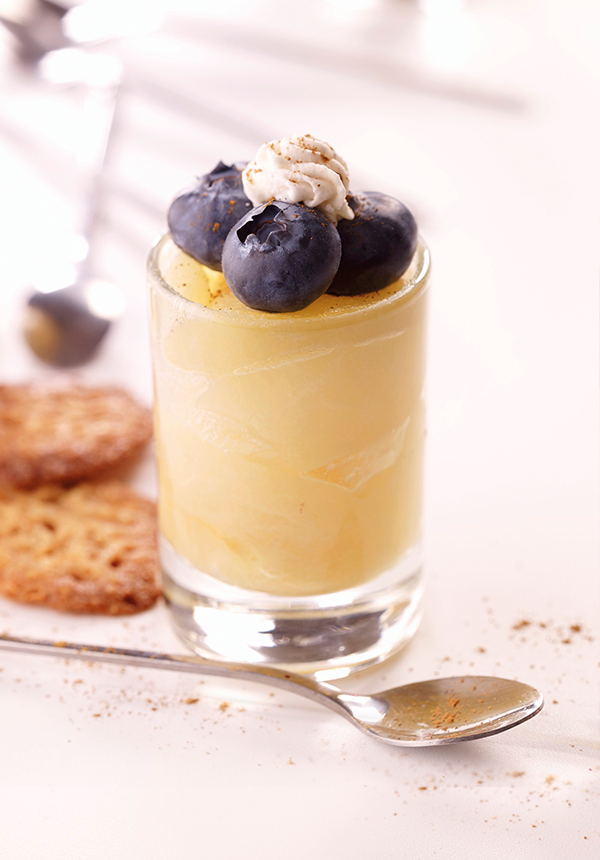 Leckeres Birnen-Heidelbeer-Dessert in einer Glasschale, dekoriert mit frischen Beeren und Minze.